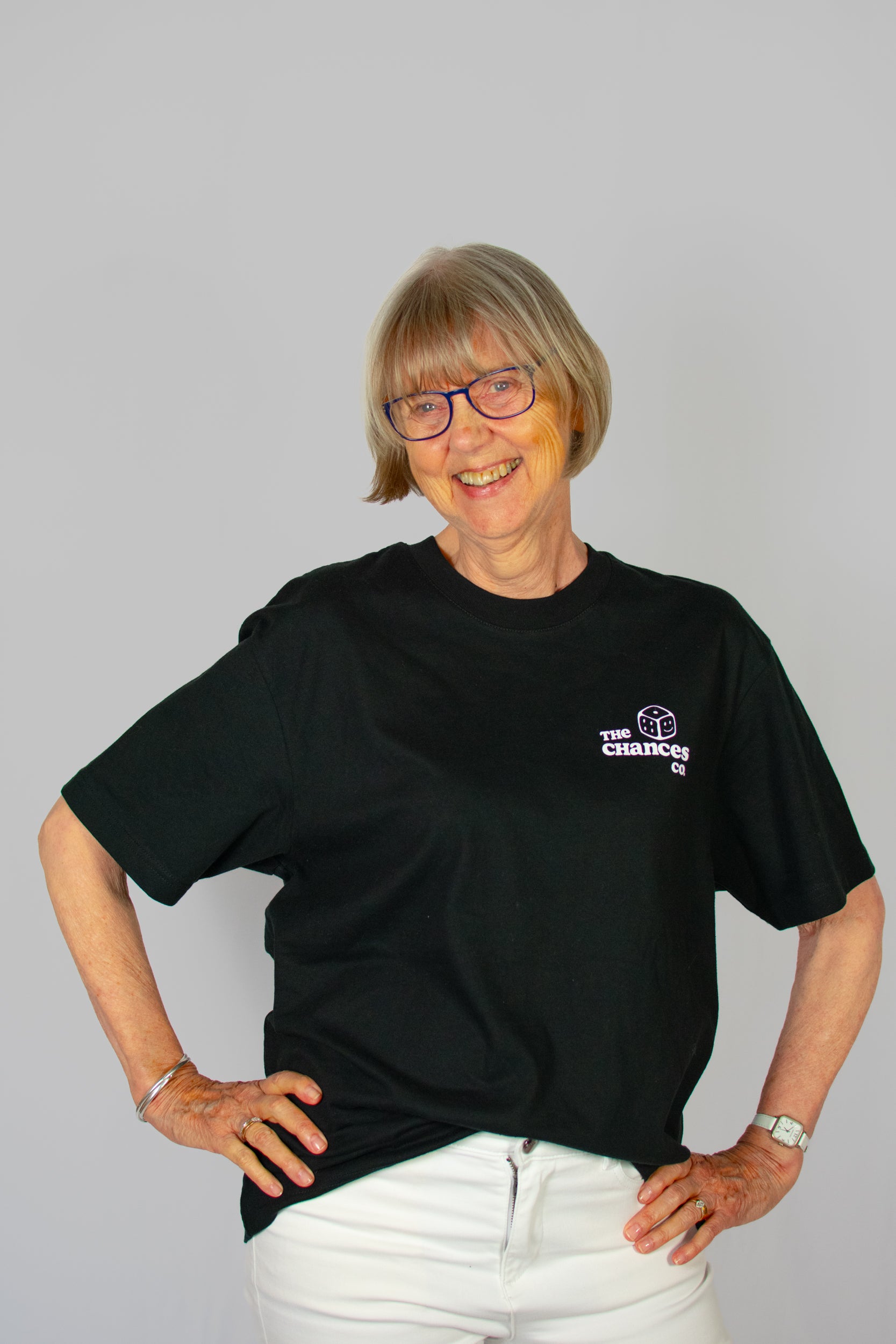 Person wearing a black t-shirt with a white dice logo on a grey background