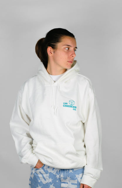 Person wearing a white hoodie with a green "the Chances Co" logo with a small smiley green dice. stood on a grey background