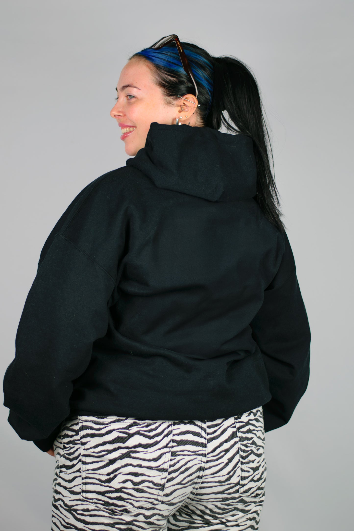 Person wearing a black Chances hoodie on a grey background