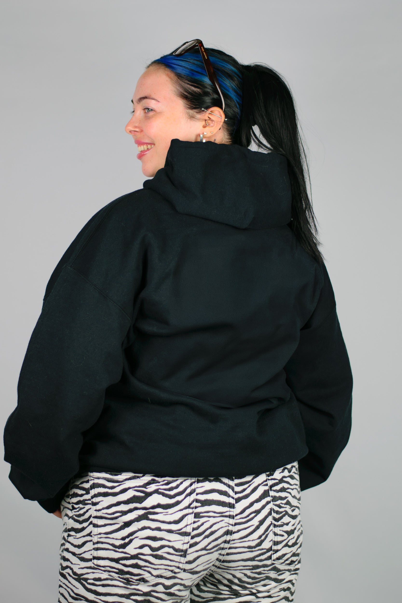 Person wearing a black Chances hoodie on a grey background