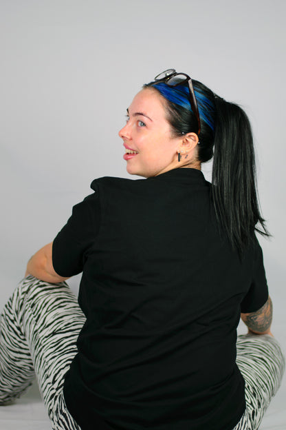 Person wearing a black Chances Clothing T-shirt and sitting on a white background